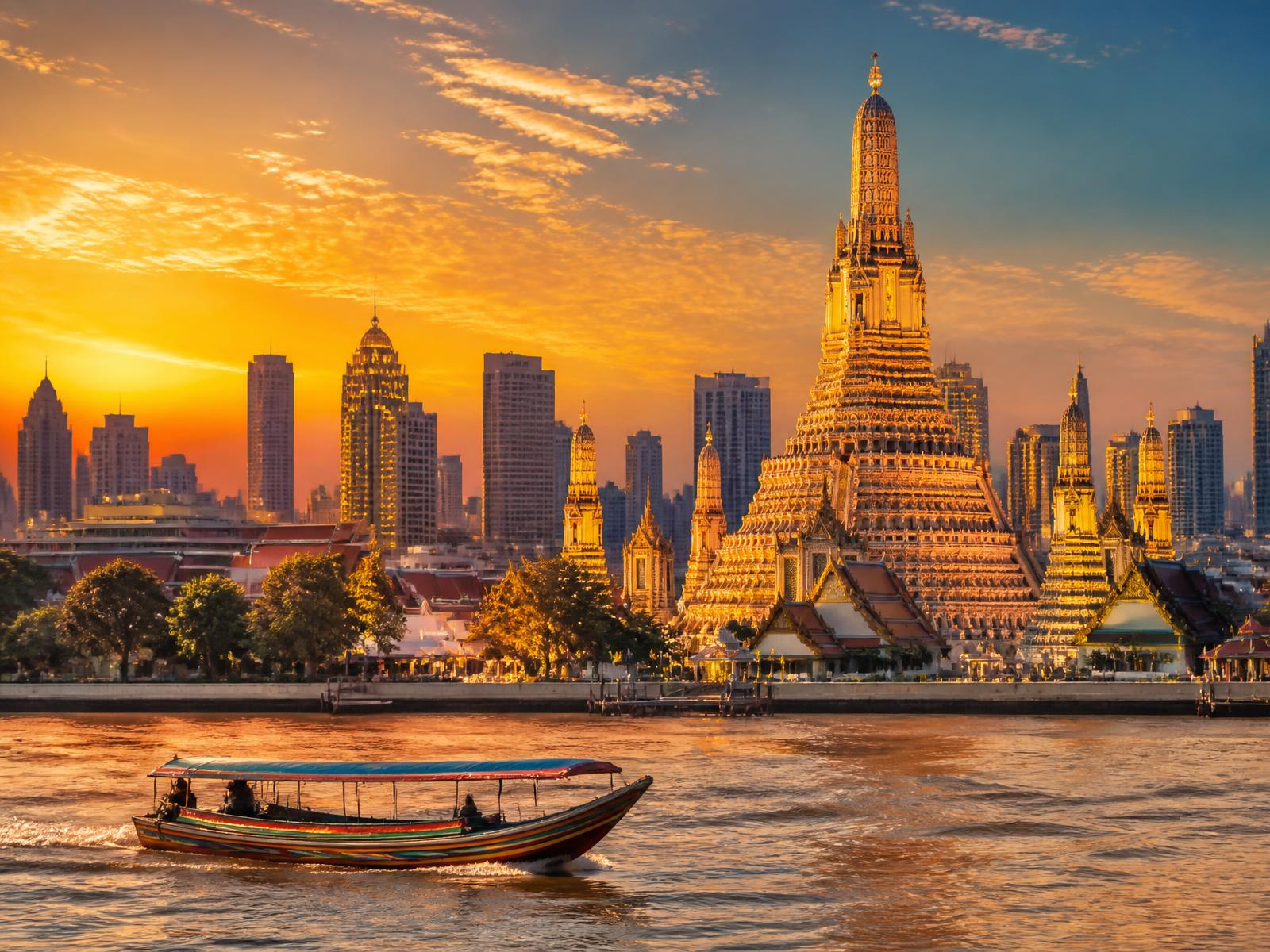 BTS skytrain crossing a busy Bangkok street at sunset